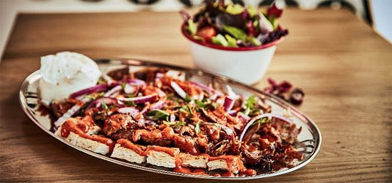   Iskender Döner Kebab © Hans Kebab  Fladenbrot mit Kalbsfleisch, knackiger Salatmix, frische Kirschtomaten, rote Zwiebeln mit Petersilie, fester Joghurt und hausgemachte Tomatensauce mit türkischer Butter  (©Foto: ©Hans Kebab)